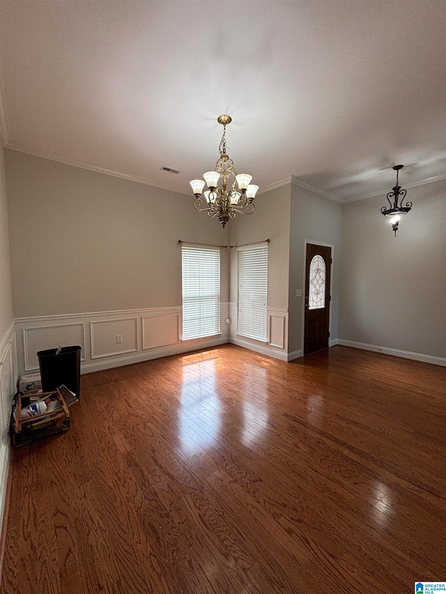 unfurnished room with dark hardwood / wood-style floors, an inviting chandelier, and ornamental molding