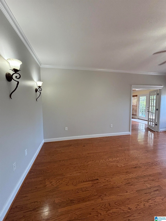 empty room featuring crown molding, dark wood-type flooring, and french doors