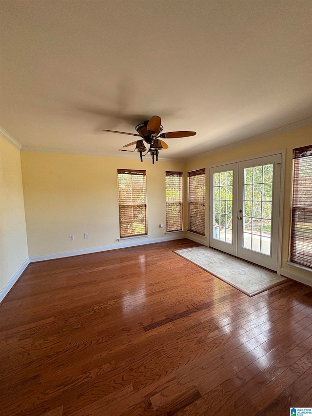 unfurnished living room with dark wood-type flooring, ceiling fan, ornamental molding, and french doors