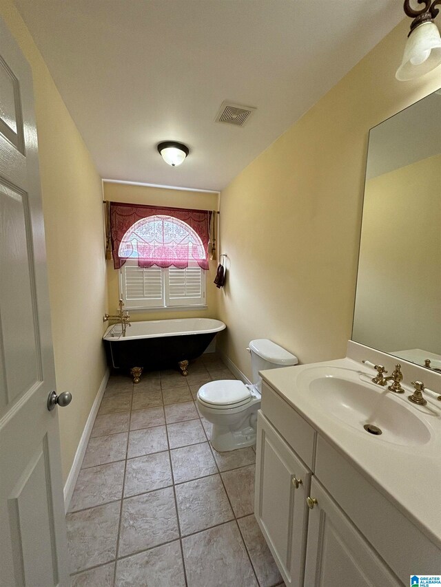 bathroom featuring a tub to relax in, vanity, toilet, and tile patterned flooring