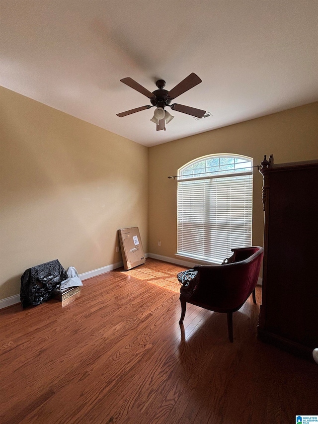 living area with hardwood / wood-style floors and ceiling fan