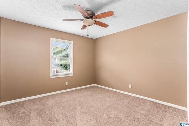 spare room featuring a textured ceiling, ceiling fan, and carpet floors