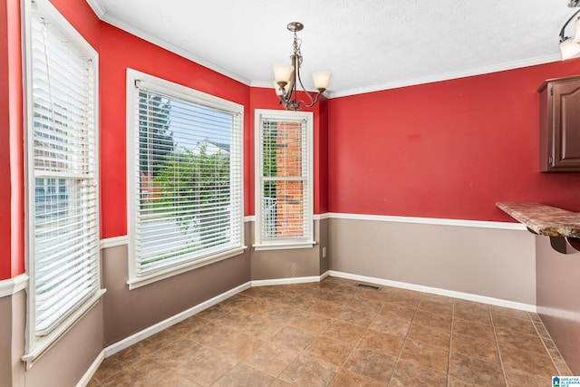 unfurnished dining area with an inviting chandelier, a textured ceiling, and ornamental molding