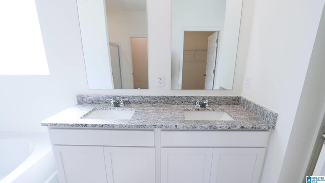 bathroom featuring vanity and a bath