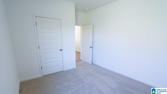 unfurnished bedroom featuring light carpet