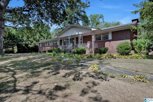 single story home featuring covered porch and a front lawn