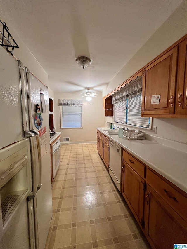 kitchen featuring white appliances, sink, and ceiling fan