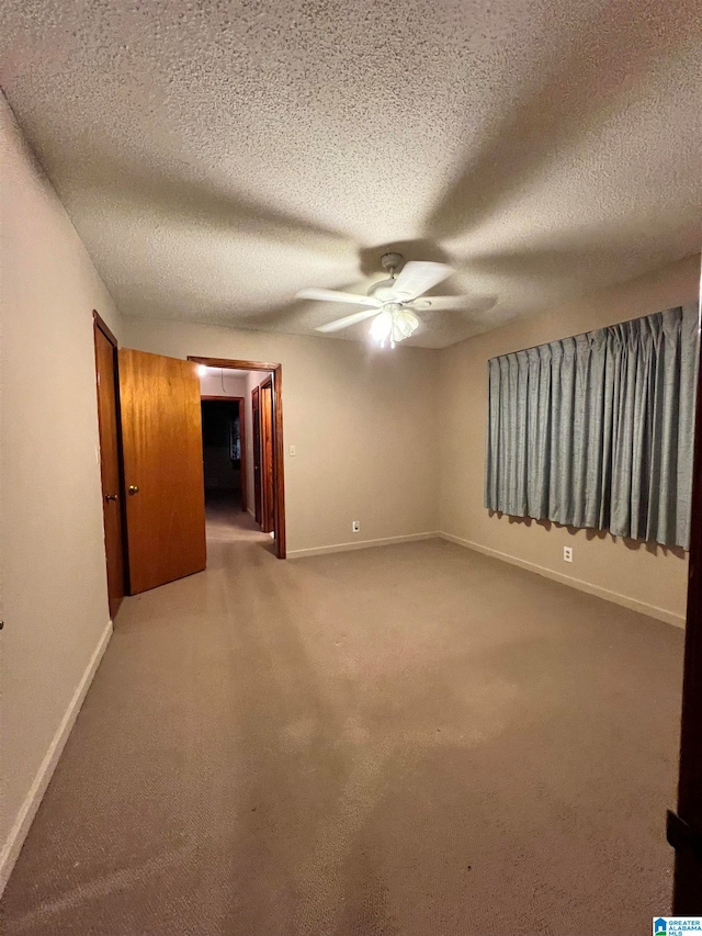 carpeted empty room featuring a textured ceiling and ceiling fan