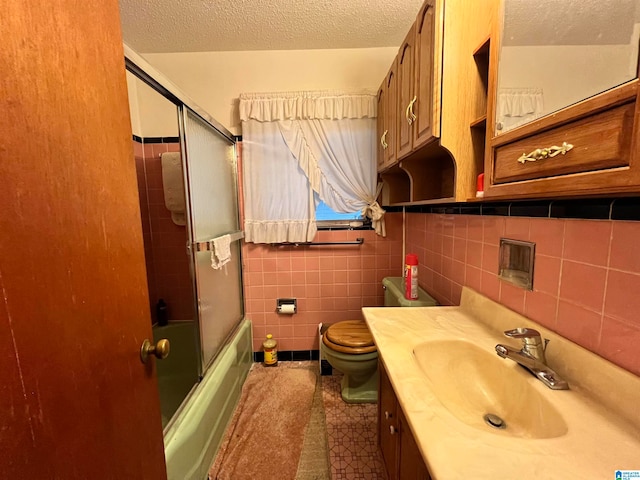 full bathroom with shower / bath combination with glass door, vanity, toilet, and a textured ceiling