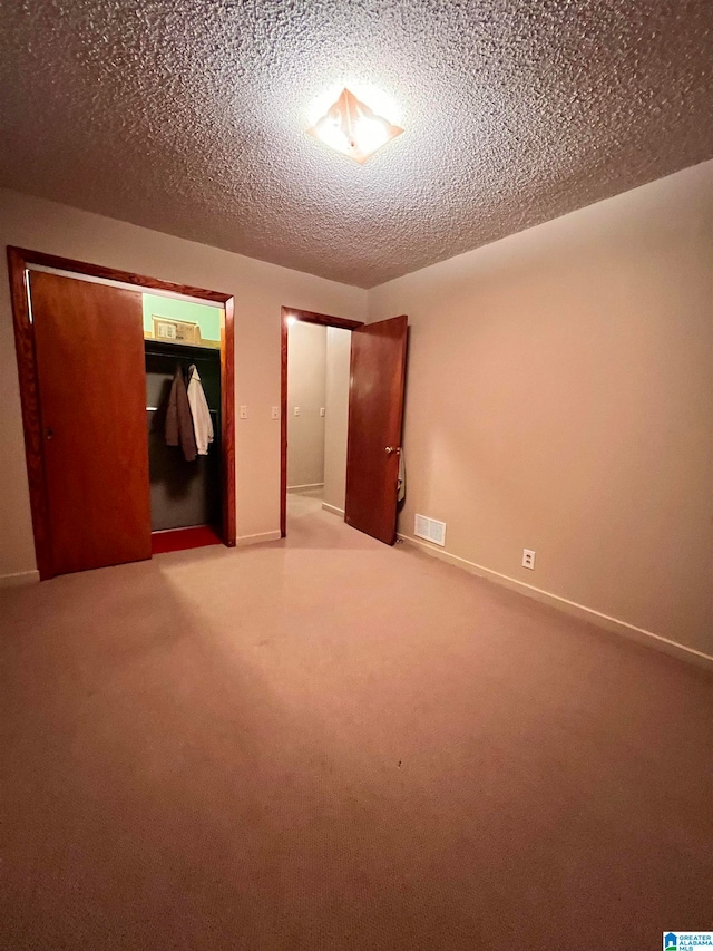 unfurnished bedroom featuring a closet, carpet floors, and a textured ceiling