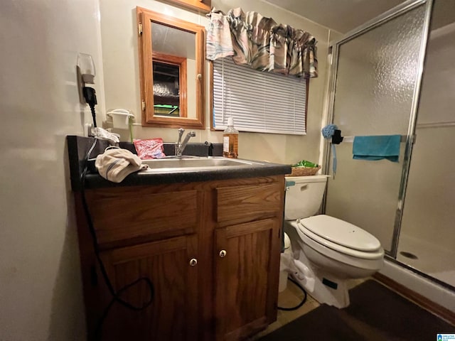 bathroom featuring vanity, toilet, and an enclosed shower