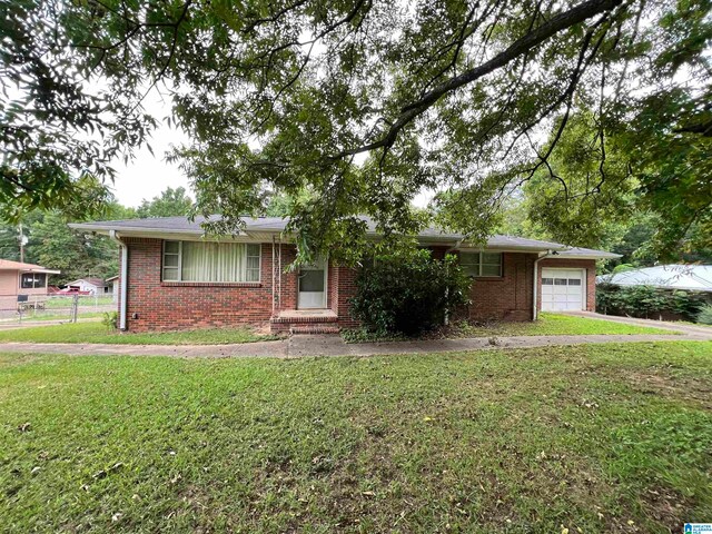 ranch-style house featuring a garage and a front lawn