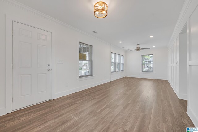 empty room featuring ceiling fan, wood-type flooring, and ornamental molding