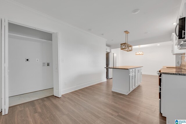 empty room with ceiling fan, ornamental molding, and hardwood / wood-style floors