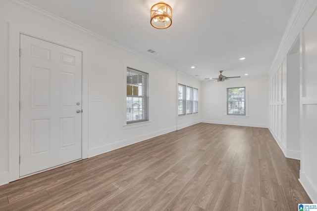 interior space featuring light wood-type flooring, ceiling fan, and ornamental molding