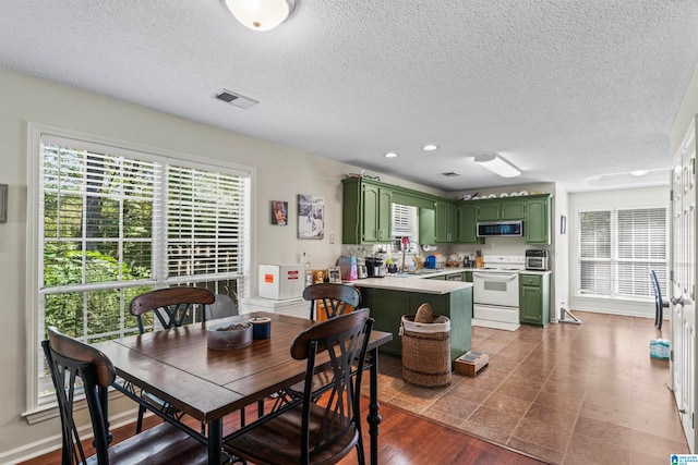 dining room featuring a textured ceiling, sink, and dark hardwood / wood-style flooring