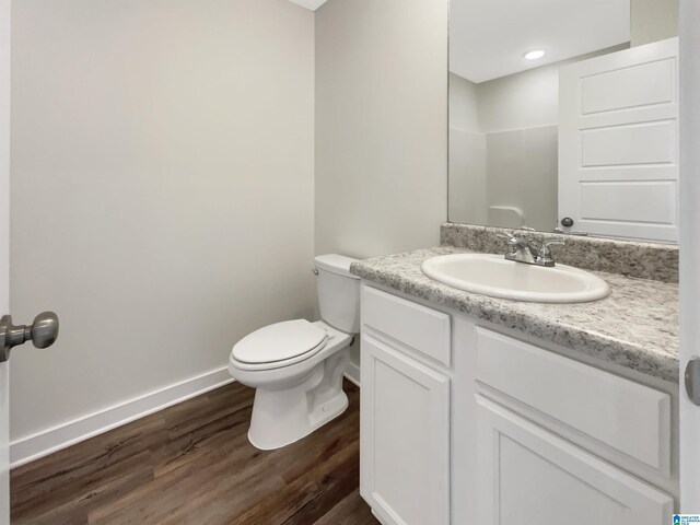 bathroom with vanity, toilet, and hardwood / wood-style flooring