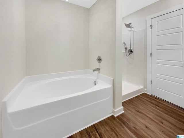 bathroom with hardwood / wood-style floors and independent shower and bath