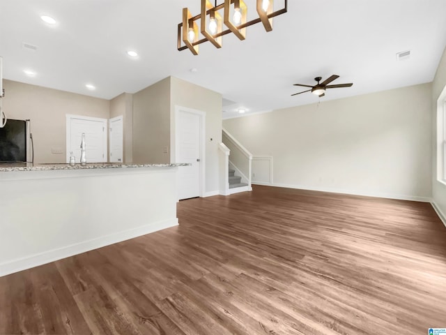 unfurnished living room featuring ceiling fan and hardwood / wood-style flooring