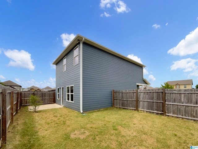 back of property with a lawn and a patio