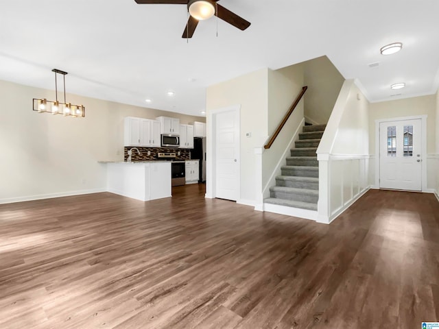 unfurnished living room featuring hardwood / wood-style flooring, sink, and ceiling fan