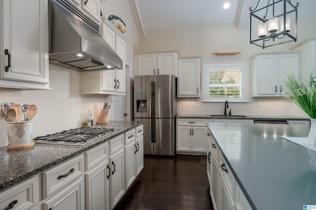 kitchen with appliances with stainless steel finishes, an inviting chandelier, white cabinetry, and sink