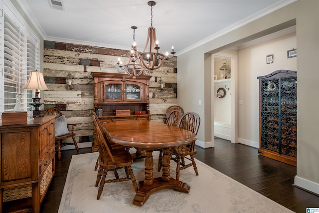 dining area with ornamental molding, wood walls, a notable chandelier, and dark hardwood / wood-style flooring