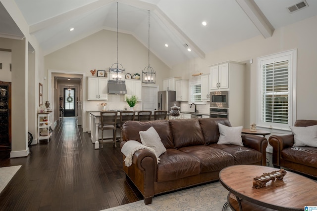 living room with an inviting chandelier, beamed ceiling, dark hardwood / wood-style flooring, sink, and high vaulted ceiling