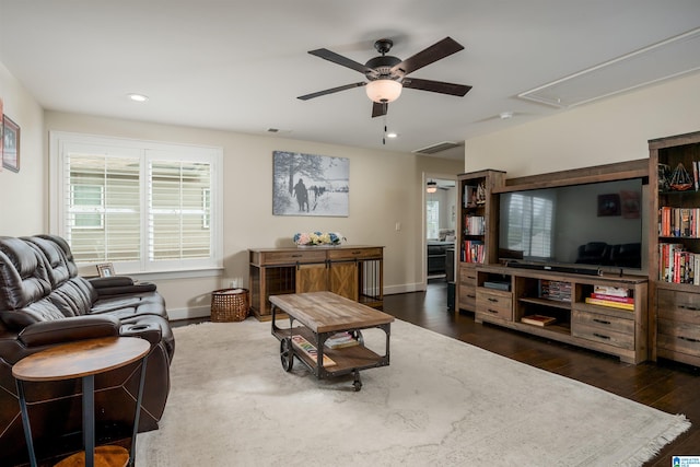 living room featuring dark wood-type flooring and ceiling fan