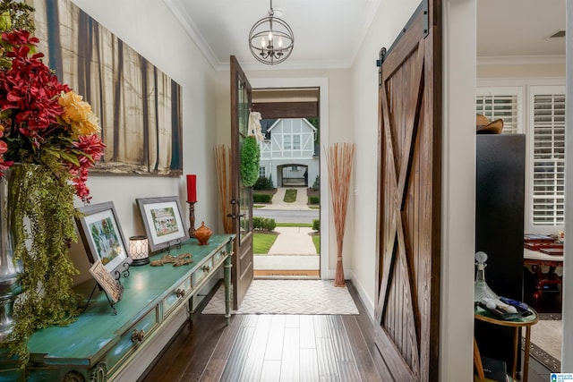 doorway to outside featuring ornamental molding, a notable chandelier, a barn door, and dark hardwood / wood-style floors