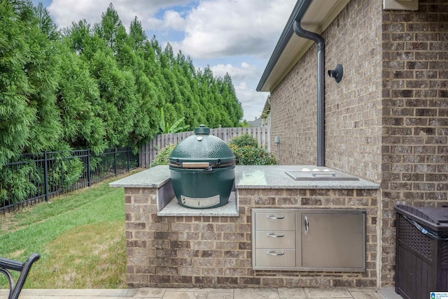 view of patio with exterior kitchen and a grill