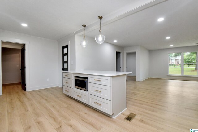 207 Friendship Cir, Clanton, AL 35045 - kitchen with light countertops, light wood-style flooring, stainless steel microwave, recessed lighting, and open floor plan