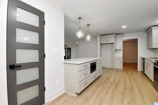 207 Friendship Cir, Clanton, AL 35045 - kitchen with light countertops, decorative light fixtures, light wood-type flooring, stainless steel appliances, and backsplash