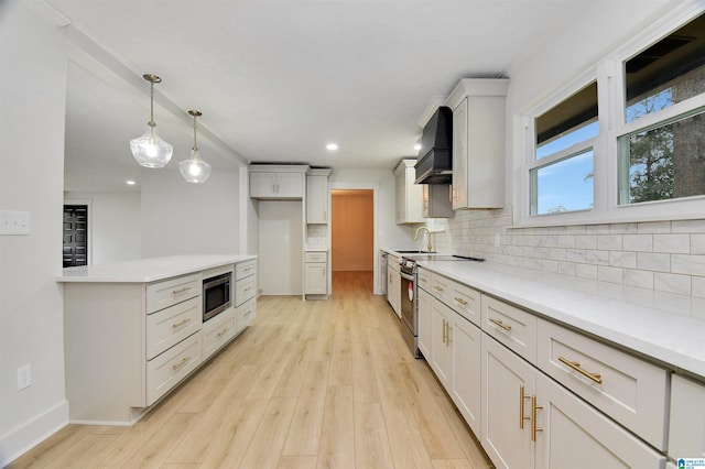 kitchen with stainless steel appliances, sink, decorative backsplash, custom range hood, and light hardwood / wood-style floors