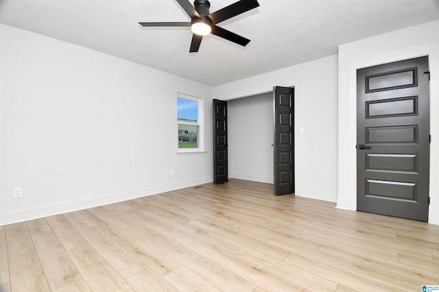 unfurnished bedroom featuring a textured ceiling, light hardwood / wood-style flooring, and ceiling fan