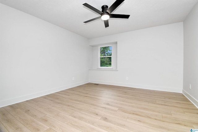 spare room featuring light wood-type flooring, a textured ceiling, and ceiling fan