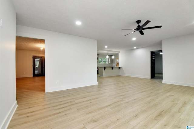 interior space with ceiling fan, a textured ceiling, and light hardwood / wood-style flooring