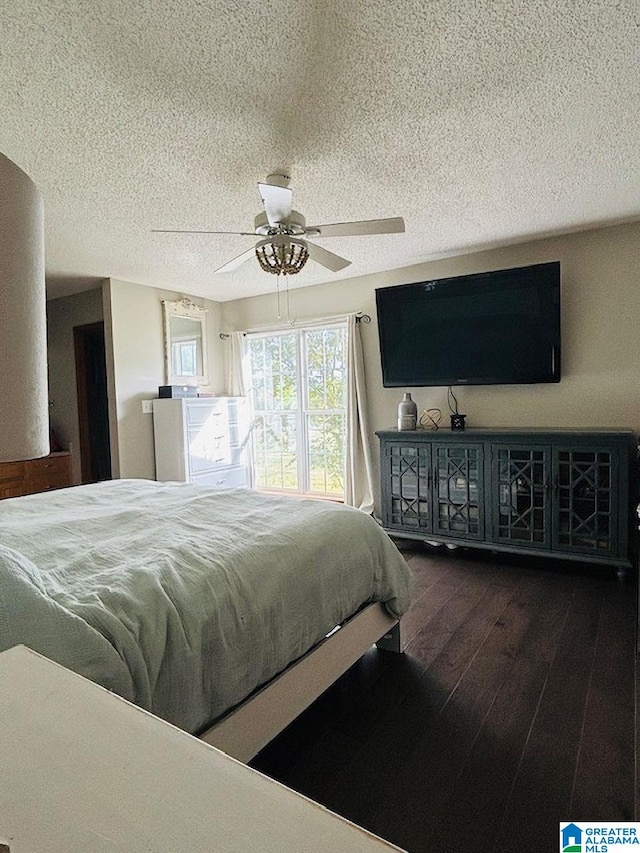 bedroom with dark wood-type flooring, a textured ceiling, and ceiling fan