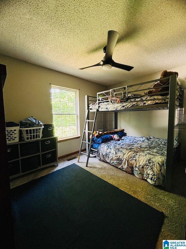 bedroom featuring carpet flooring, ceiling fan, and a textured ceiling