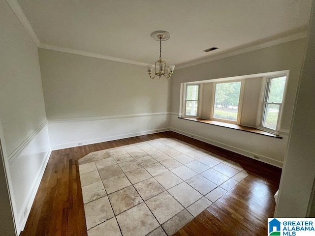 spare room with crown molding, a notable chandelier, and hardwood / wood-style floors