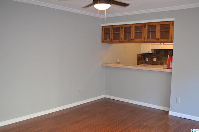 kitchen featuring ceiling fan, dark wood-style floors, baseboards, and ornamental molding