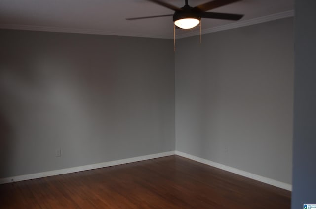 spare room featuring ceiling fan, dark wood-type flooring, and ornamental molding