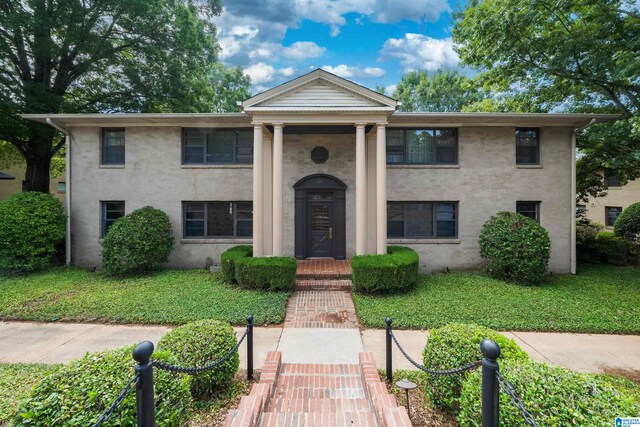 neoclassical / greek revival house featuring a front yard