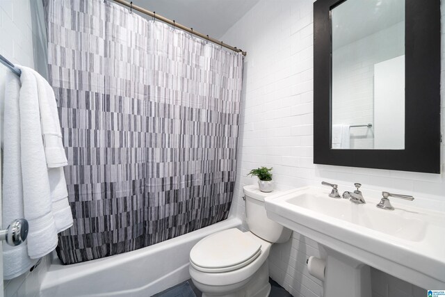 bathroom with tile walls, toilet, and shower / bathtub combination with curtain