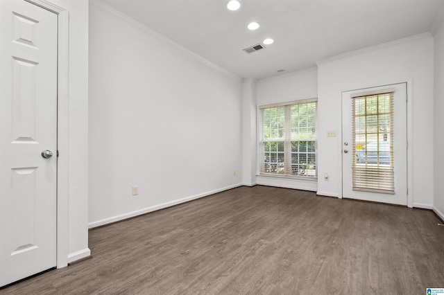 empty room with ornamental molding and dark hardwood / wood-style floors