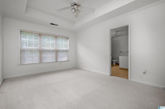 unfurnished room featuring light carpet, a raised ceiling, ornamental molding, and ceiling fan