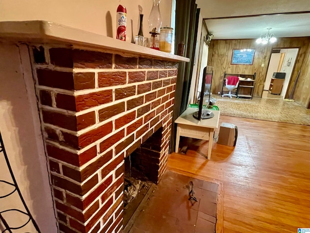 details with hardwood / wood-style floors, wood walls, and a brick fireplace