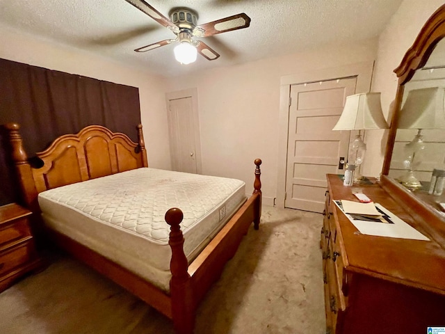 carpeted bedroom with a textured ceiling and ceiling fan