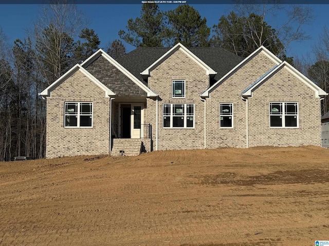 craftsman inspired home with brick siding and a front lawn