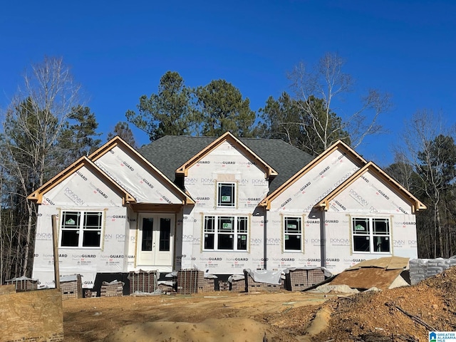 view of front of home featuring french doors, stucco siding, and a shingled roof